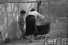 1992, Republika Inguszetii.
Życie codzienne na wsi. Kobieta pochyla się nad kociołkiem, obok stoi jej synek.
Fot. Mikołaj Nesterowicz, zbiory Ośrodka KARTA