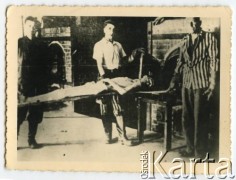 1945, Dachau, Rzesza Niemiecka.
Wyzwoleni przez amerykańskich żołnierzy byli więźniowie obozu koncentracyjnego demonstrują wrzucanie zwłok do pieca krematoryjnego.
Fot. NN, kolekcja Józefa Iwaniszyna, reprodukcje cyfrowe w Ośrodku KARTA