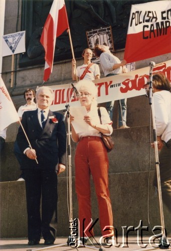 Lata 80., Londyn, Anglia, Wielka Brytania.
Trafalgar Square. Demonstracja zorganizowana przez działaczy polonijnych skupionych wokół ruchu Solidarity with Solidarity, popierających ruch NSZZ Solidarność w Polsce. Na podeście kolumny Nelsona przemawia Tessa Ujazdowska, obok niej stoi Artur Rymkiewicz, minister rządu RP na Uchodźstwie. 
Fot. NN, kolekcja Tessy Ujazdowskiej, reprodukcje cyfrowe w Ośrodku KARTA