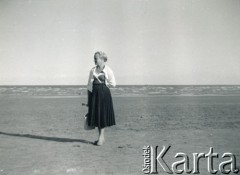 1962, New Romney, Anglia, Wielka Brytania. 
Irena Wolicka-Wolszleger (z domu Ćwirko) spaceruje po plaży nad morzem. 
Fot. NN, kolekcja Ireny Wolickiej-Wolszleger, reprodukcje cyfrowe w Ośrodku KARTA