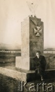 Po 1947, brak miejsca.
Kobieta siedzi pod pomnikiem z Orderem Virtuti Millitari i napisem 
