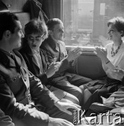 1964, Warszawa, Polska.
Dworzec Gdański, n/z pasażerowie (m.in. żołnierze na przepustce) w przedziale pociągu.
Fot. Marek Zürn, zbiory Fundacji Ośrodka KARTA