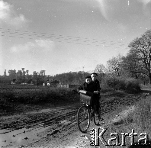 Lata 60., miejsce nieznane, Polska.
Chłopcy na rowerze na wiejskiej drodze.
Fot. Marek Zürn, zbiory Fundacji Ośrodka KARTA