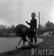 Lata 60., Warszawa, Polska.
Dzieci na placu zabaw na Żoliborzu, n/z matka zapina synowi wrotki.
Fot. Marek Zürn, zbiory Fundacji Ośrodka KARTA