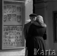 Lata 60., Warszawa, Polska.
Mężczyzna i kobieta podczas rozmowy  przy witrynie fotografa na ulicy warszawskiej Pragi.
Fot. Marek Zürn, zbiory Fundacji Ośrodka KARTA