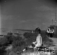 Lata 60., Płock, Polska.
Występy zespołów ludowych na estradzie nad Wisłą, n/z jedna z uczestniczek na skarpie.
Fot. Marek Zürn, zbiory Fundacji Ośrodka KARTA