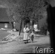 Lata 60., Mazowsze, Polska.
Starsza kobieta z dzieckiem na wiejskiej drodze.
Fot. Marek Zürn, zbiory Fundacji Ośrodka KARTA