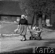 Lata 60., Mazowsze, Polska.
Kobieta z dziećmi w wózku na wiejskiej drodze.
Fot. Marek Zürn, zbiory Fundacji Ośrodka KARTA