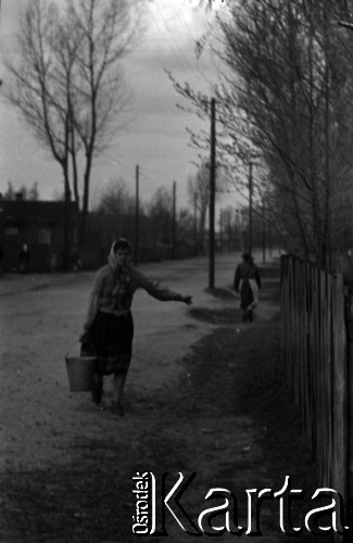 Lata 60., miejsce nieznane, Polska.
Kobieta niesie wodę w wiadrze.
Fot. Marek Zürn, zbiory Fundacji Ośrodka KARTA