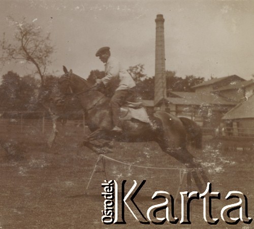1900-1920, Sokola Góra, Polska.
Ćwiczenia jeździeckie. Mężczyzna siedzi na koniu, skacze przez przeszkodę. W tle widać budynek gorzelni w Sokolej Górze.
Fot. NN, kolekcja rodziny Walińskich, zbiory Fundacji Ośrodka KARTA