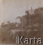 1900-1920, miejsce nieznane, Polska.
Młócenie. Chłopki i chłopi podczas pracy. Odzielają ziarna od słomy przy pomocy maszyny.
Fot. NN, kolekcja rodziny Walińskich, zbiory Fundacji Ośrodka KARTA