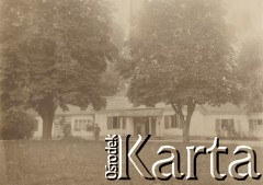 1900-1920, miejsce nieznane.
Dwór między drzewami. Na trawie przed dworem stoi mężczyzna, na ganku kobieta.
Fot. NN, kolekcja rodziny Walińskich, zbiory Fundacji Ośrodka KARTA