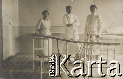 1900-1920, miejsce nieznane, Polska.
Personel szpitala w sali. Dwie kobiety i mężczyzna stoją za łóżkiem szpitalnym.
Fot. NN, kolekcja rodziny Walińskich, zbiory Fundacji Ośrodka KARTA