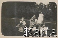 1920-1930, miejsce nieznane, Polska.
Kobieta z dziećmi na trawie. W tle droga, łąka, drzewa.
Fot. NN, kolekcja rodziny Walińskich, zbiory Fundacji Ośrodka KARTA