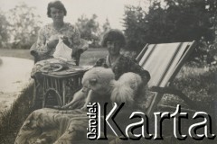 1930-1940, miejsce nieznane, Polska.
Kobieta i dziewczynka. Kobieta zajmuje się robótkami ręcznymi, dziewczynka siedzi na leżaku z psami.
Fot. NN, kolekcja rodziny Walińskich, zbiory Fundacji Ośrodka KARTA