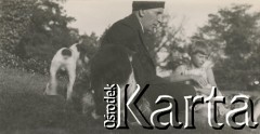 1930-1940, miejsce nieznane, Polska.
Mężczyzna, dziewczynka i zwierzęta. Siedzą na trawie.
Fot. NN, kolekcja rodziny Walińskich, zbiory Fundacji Ośrodka KARTA
