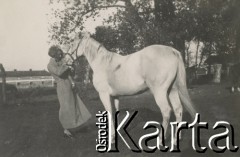 1930-1940, miejsce nieznane, Polska.
Zagroda. Kobieta pokazuje dziecku konia.
Fot. NN, kolekcja rodziny Walińskich, zbiory Fundacji Ośrodka KARTA