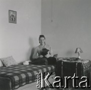 1930-1950, miejsce nieznane, Polska.
Kobieta. Siedzi na łóżku i trzyma psa.
Fot. NN, kolekcja rodziny Walińskich, zbiory Fundacji Ośrodka KARTA