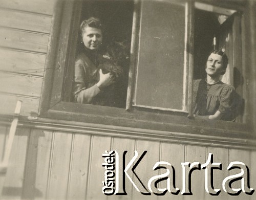 1930-1950, miejsce nieznane, Polska.
Dwie kobiety w oknie. Jedna trzyma psa.
Fot. NN, kolekcja rodziny Walińskich, zbiory Fundacji Ośrodka KARTA