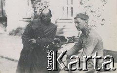 1930-1950, miejsce nieznane, Polska.
Mężczyźni. Jeden siedzi na motocyklu. Drugi opiera się o kierownicę.
Fot. NN, kolekcja rodziny Walińskich, zbiory Fundacji Ośrodka KARTA