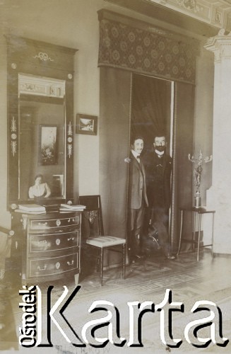 1910-1920, Piotrków Trybunalski, Polska.
Mężczyźni. Stoją w drzwiach do pokoju. W odbiciu lustraznym widać kobietę.
Fot. NN, kolekcja rodziny Walińskich, zbiory Fundacji Ośrodka KARTA