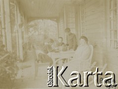 1907, Połąga, Litwa.
Spotkanie rodzinne na werandzie domu, położonego wśród drzew. N/z (przy stole) Jadwiga Walińska (1P) z dziećmi.
Fot. NN, kolekcja rodziny Walińskich, zbiory Fundacji Ośrodka KARTA
