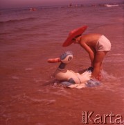 Lipiec 1963, Krynica Morska, Polska.
Chłopiec w kapeluszu kąpie się w morzu razem z nadmuchiwaną kaczką.
Fot. Romuald Broniarek, zbiory Ośrodka KARTA