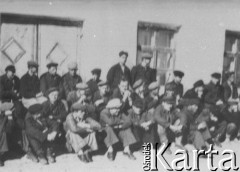 Brak daty, Kazachska SRR, ZSRR.
Grupa mężczyzn w czapkach-leninówkach siedzi na tle budynku.
Fot. NN, zbiory Ośrodka KARTA, udostępnił Edward Karluk