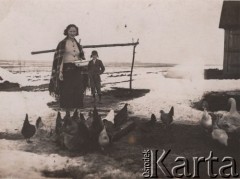 1920-1939, Wileńszczyzna, Polska
Kobieta karmiąca kury na podwórku przed domem.
Fot. NN, zbiory Ośrodka KARTA, udostępnił Ryszard Mackiewicz.