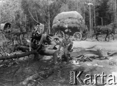 Lato 1941, miejsce nieznane, Polska.
Tabory wojskowe na szosie białostockiej, niemiecki lotnik obok zniszczonego sprzętu wojskowego. 
Fot. z albumu gen. Hellmutha Bienecka, przekazał Piotr Kleeberg, zbiory Fundacji Ośrodka KARTA