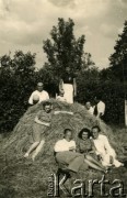 1940, Rumunia.
Polscy uchodźcy w Rumunii podczas II wojny światowej - grupa osób w letnich ubraniach siedzi na sianie.
Fot. NNH, zbiory Ośodka KARTA, udostępnił Adam Krajewski.