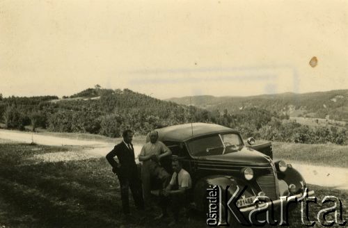1940, Rumunia.
Polacy w Rumunii podczas II wojny światowej: Tadeusz Krajewski i dwaj mężczyźni NN przy samochodzie, w tle góry; na odwrocie pieczęć: