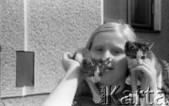 Lata 60. lub 70., Polska.
Dziewczynka z kotami.
Fot. Irena Jarosińska, zbiory Ośrodka KARTA