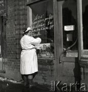 lata 50-te, Polska
Ekspedientka zapisuje menu na oknie.
Fot. Irena Jarosińska, zbiory Ośrodka KARTA