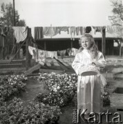 lata 50-te, Polska
Dziewczynka z koszykiem kwiatów w drodze na procesję Bożego Ciała.
Fot. Irena Jarosińska, zbiory Ośrodka KARTA