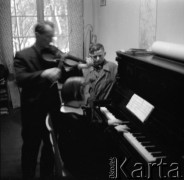 1950-1960, Leszno, Polska.
Lekcja muzyki. Mężczyzna akompaniuje dziewczynce grajacej na pianinie.
Fot. Irena Jarosińska, zbiory Ośrodka KARTA