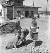 lata 50-te, Warszawa, Polska
Dzieci bawią się z psem na podwórku przed domem.
Fot. Irena Jarosińska, zbiory Ośrodka KARTA