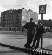 lata 50-te, Warszawa, Polska.
Mężczyźni rozmawiający na chodniku przy ulicy Targowej (róg Okrzei, do 1948 Brukowej). Jeden z nich opiera się o znak z napisem: 