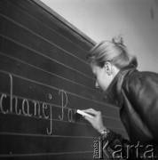 lata 70-te, Warszawa, Polska
Kobieta pisze na tablicy szkolnej.
Fot. Irena Jarosińska, zbiory Ośrodka KARTA