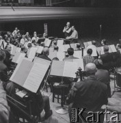 1965, Warszawa, Polska.
Międzynarodowy Festiwal Muzyki Współczesnej „Warszawska Jesień”. Włoski kompozytor Luigi Nono (siedzi przed orkiestrą) z dyrygentem Andrzejem Markowskim (obok Nono) w Filharmonii Narodowej.
Fot. Irena Jarosińska, zbiory Ośrodka KARTA