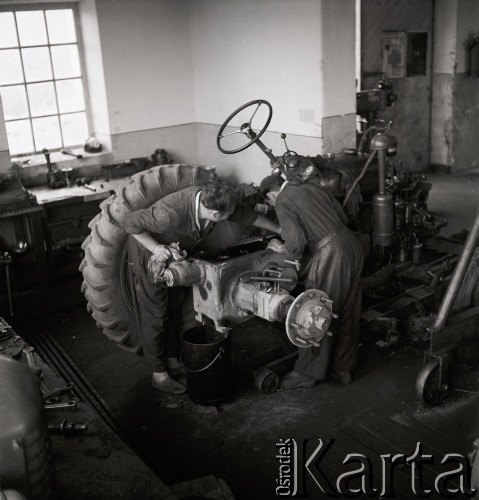lata 50-te, Puck, Polska
Brygadier pomaga pracownikowi Produkcyjnego Ośrodka Maszynowego w naprawie traktora.
Fot. Irena Jarosińska, zbiory Ośrodka KARTA