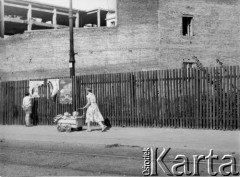 1950-1969, Warszawa, Polska
Warszawska ulica: kobieta z wózkiem, chłopiec oglądający plakaty.
Fot. Irena Jarosińska, zbiory Ośrodka KARTA