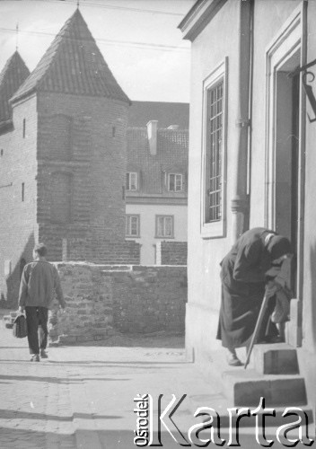 1950-1969, Warszawa, Polska
Stare Miasto - kobieta wchodzi do domu przy ul. Krzywe Koło 30, w tle widać Barbakan.
Fot. Irena Jarosińska, zbiory Ośrodka KARTA
