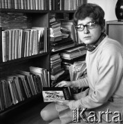 1970, Warszawa, Polska.
Ewa Długosz, urodzona w obozie koncentracyjnym Ravensbruck, n/z w mieszkaniu, z tomikiem poezji obozowej.
Fot. Irena Jarosińska, zbiory Ośrodka KARTA