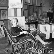 Lata 60., Kraków, Polska.
Jadwiga Waśkowska, wdowa po Antonim Waśkowskim, poecie i malarzu. W tle obrazu Antoniego Waśkowskiego.
Fot. Irena Jarosińska, zbiory Fundacji Ośrodka KARTA