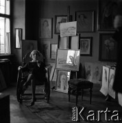 Lata 60., Kraków, Polska.
Jadwiga Waśkowska, wdowa po Antonim Waśkowskim, poecie i malarzu. W tle obrazu Antoniego Waśkowskiego.
Fot. Irena Jarosińska, zbiory Fundacji Ośrodka KARTA