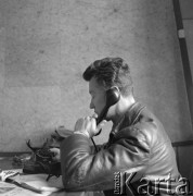 1960-1965, Katowice, woj. śląskie, Polska.
Pilot sanitarny w Zespole Lotnictwa Sanitarnego przy Wojskowej Stacji Pogotowia Ratunkowego Edward Makula (1930-1996) rozmawia przez telefon w biurze. 
Fot. Irena Jarosińska, zbiory Ośrodka KARTA
