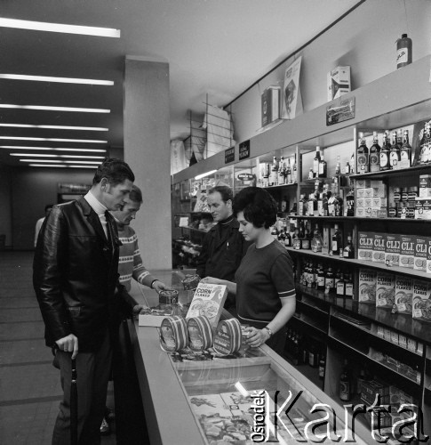 1968-1972, Kraków lub Rzeszów, Polska.
Sklep Banku PeKaO. Mężczyźni oglądają towary.
Fot. Irena Jarosińska, zbiory Ośrodka KARTA