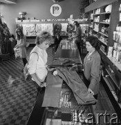 1968-1972, Nowy Targ, Polska.
Klientka ogląda spodnie w sklepie Banku PeKaO.
Fot. Irena Jarosińska, zbiory Ośrodka KARTA