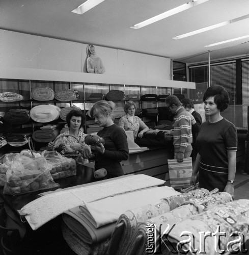 1968-1972, Kraków lub Rzeszów, Polska.
Klienci oglądają towary w dziale tkanin w sklepie Banku PeKaO.
Fot. Irena Jarosińska, zbiory Ośrodka KARTA